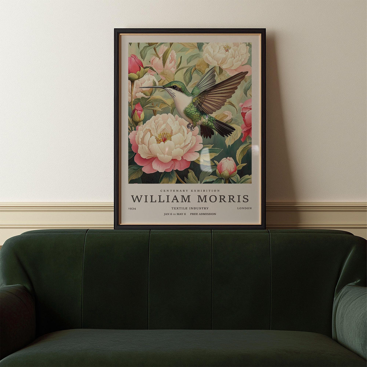 Hummingbird prints showing a hummingbird and pink peonies framed above a dark green leather sofa