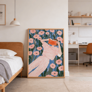Woman Reading art print leaning on floor with pink flowers and person in striped clothes in neutral bedroom