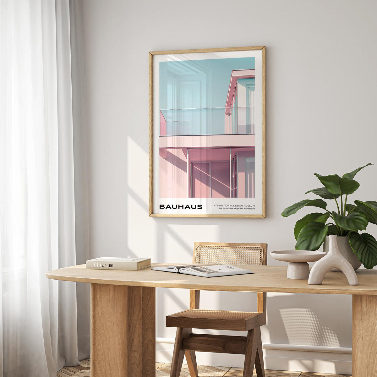 Bauhaus Style wall art of a minimalist pink building with a blue sky above a wooden table