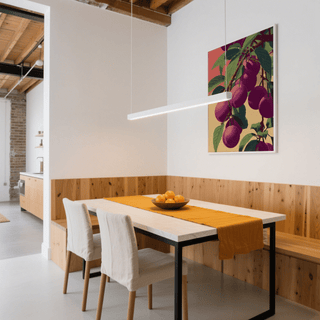 Plum Poster hung above dining table with orange runner in modern dining room