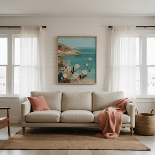 Floral Coast Print wall art with coastal flowers and blue sea above a beige sofa with a pink cushion