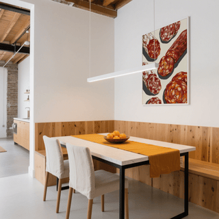 Italian Salami Print on the wall in a dining room with wood panelling and a bowl of oranges on the table