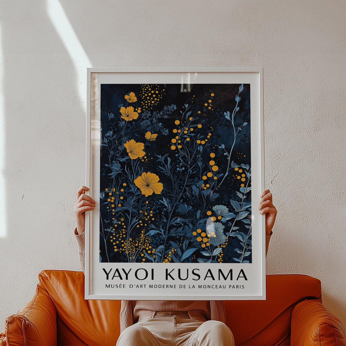 Framed Orange and Blue Wall Art held above a brown leather seat showing yellow and blue flowers