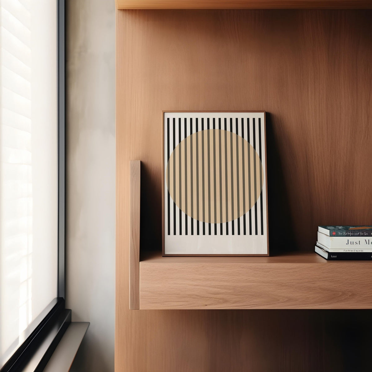 Print leaning on a wooden shelf with black stripes intersecting a beige circle next to stacked books