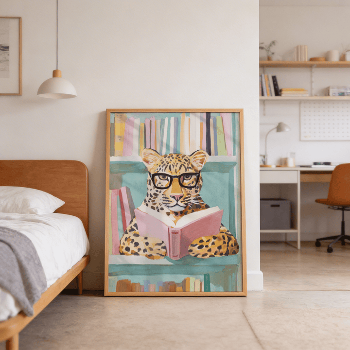 Reading Leopard Art Print leaning on the floor showing a colourful leopard with glasses holding a pink book in a bedroom