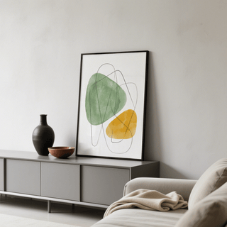 Abstract watercolor art print leaning on grey sideboard with black vase and wooden bowl in a living room