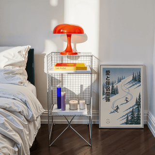 Snowboarding wall art of two snowboarders in blue and white leaning on the floor beside a metal shelf with candles