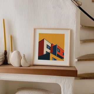 Print leaning on a shelf showing a modern abstract building in red yellow and blue next to candles and pottery