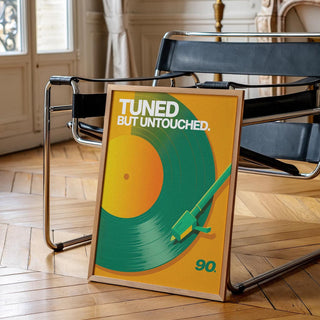 Print leaning on a black chair of vinyl record art print with green and orange tones in a classic room