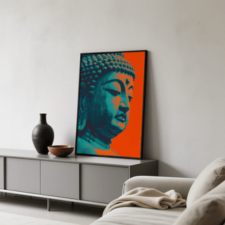 Buddha wall art leaning on grey sideboard with orange and blue minimalist design and black frame