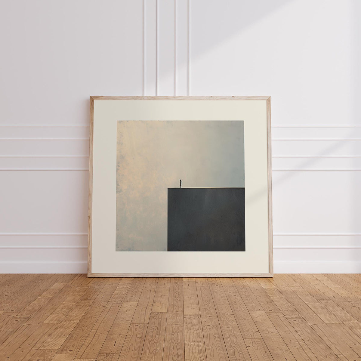Print leaning on floor of surreal black and white art with a person on cliff edge