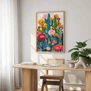 Cactus Flower Art print on a wall with bright pink yellow and green botanical illustration above a wooden dining table with a plant