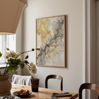 Beige abstract print in gold and grey tones on a dining room wall above wooden chairs