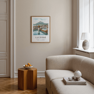 Lucerne Watercolor Art Print framed on a beige wall above a sofa with a wooden side table and bowl