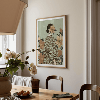Print on a wall in a dining room of a woman with flowers wearing a leaf patterned dress with muted greens