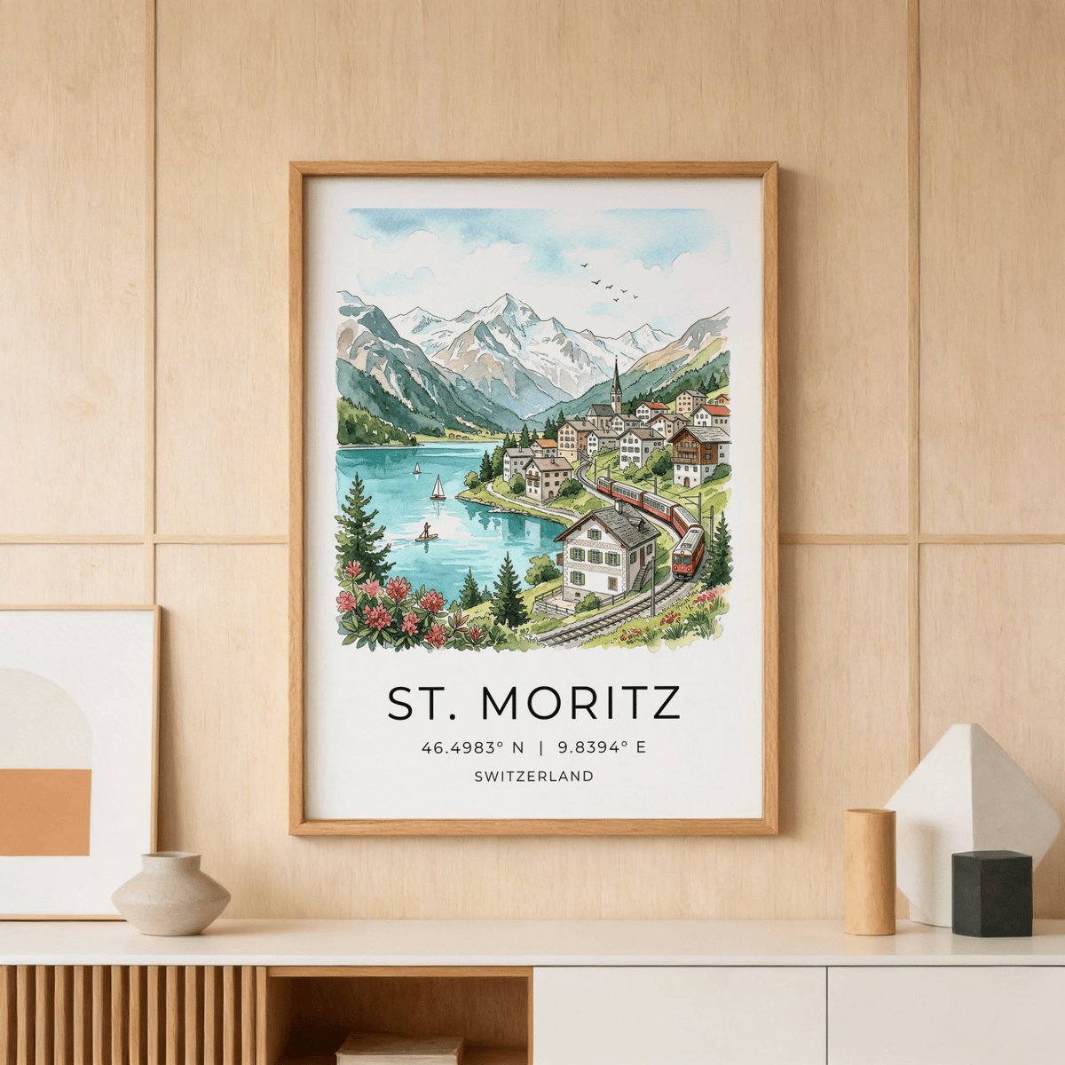 Framed print of Swiss Landscape Art Print showing mountain village with lake and a red train on a wooden wall
