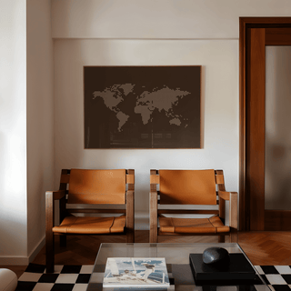 World Map Poster above two leather chairs in a minimalist room with a glass coffee table and checkered rug