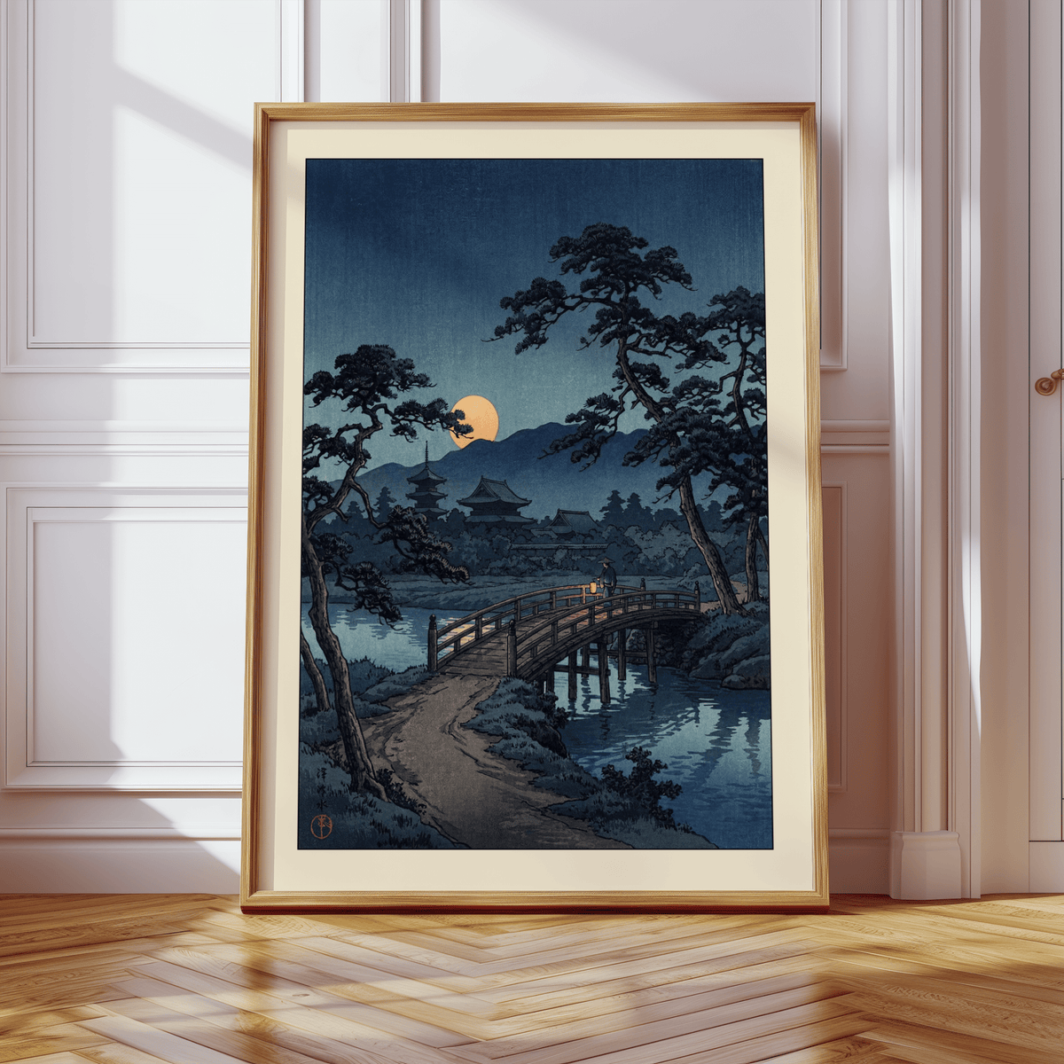 Framed Moonlit Bridge art print leaning on a wooden floor with light shadows