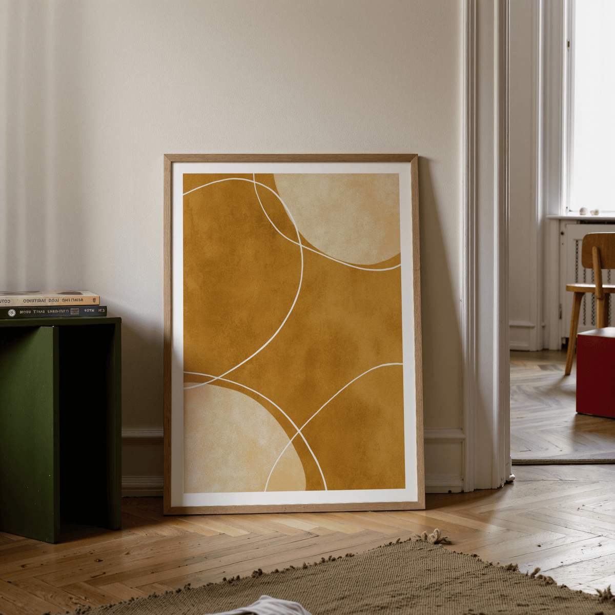 Minimalist geometric art print with abstract curved shapes in warm brown tones leaning on floor near green side table