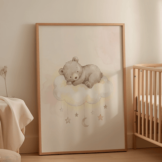 Print leaning on floor of Bear Cloud Art Print with sleeping brown bear on white cloud beside a wooden crib