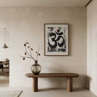 Abstract Om art print with black and orange hues above a wooden bench with a vase