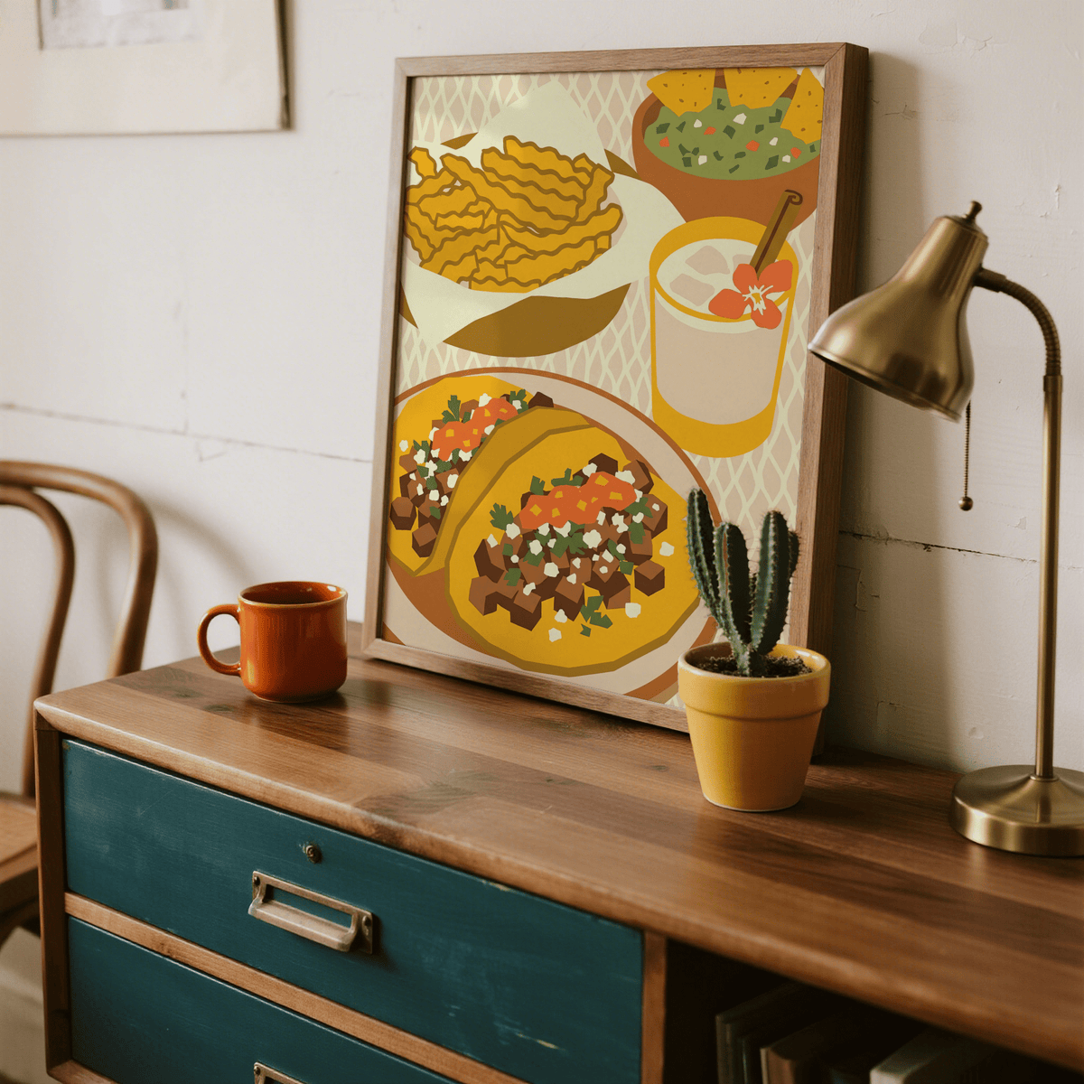 Mexican Cuisine Poster print leaning on a wooden desk with a small cactus and a lamp nearby