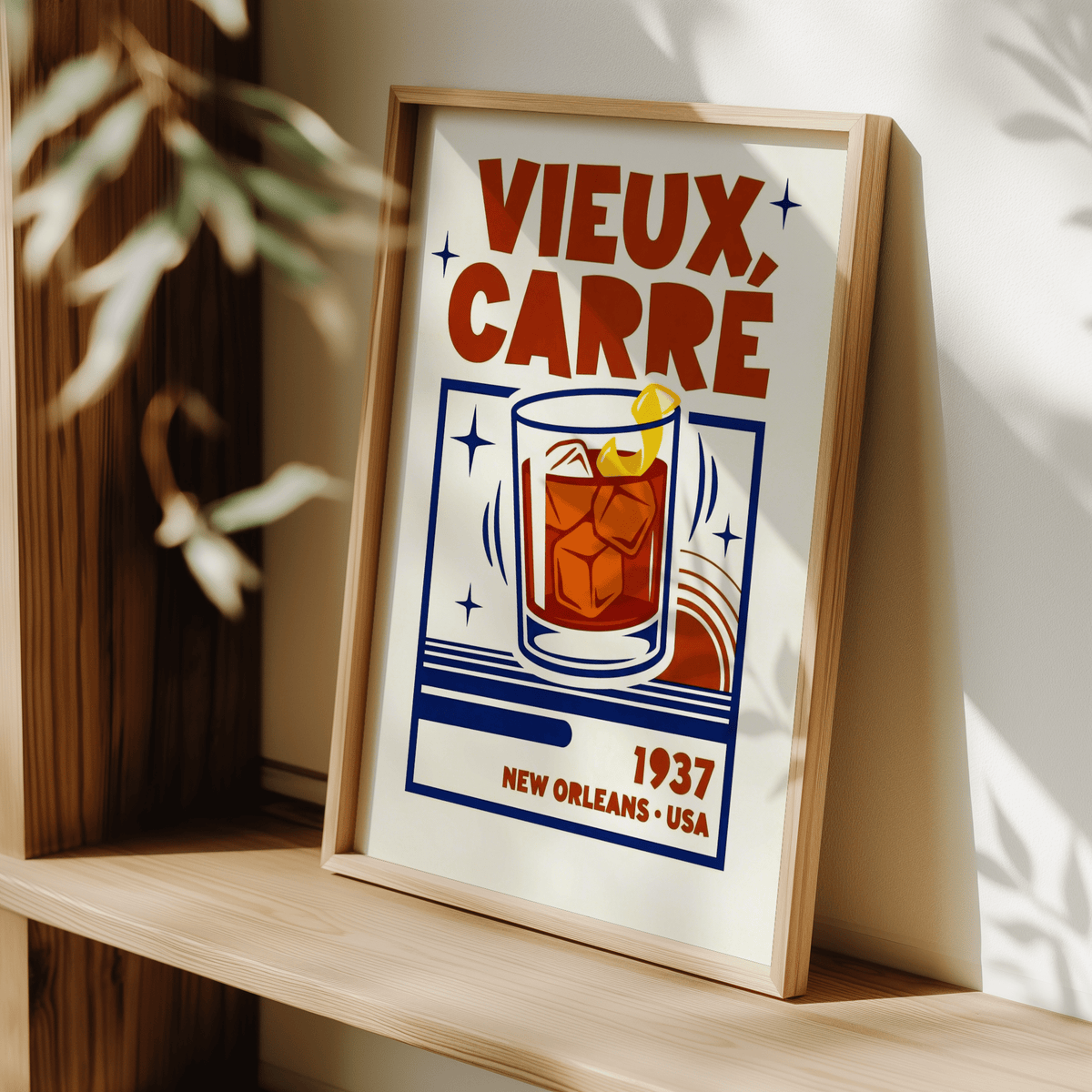 Print leaning on a shelf showing a retro cocktail glass with ice and lemon twist in red and blue tones
