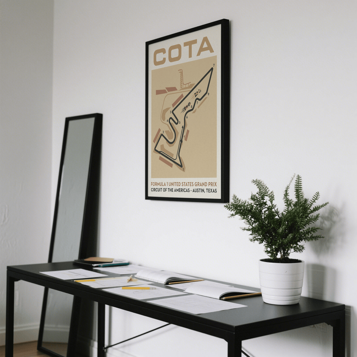 Race Track Map Poster showing stylised circuit map in beige and black above a desk with papers and a potted plant
