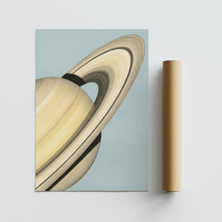 Saturn wall art print with a minimalist illustration of the planet on a pale blue background next to a brown packaging tube
