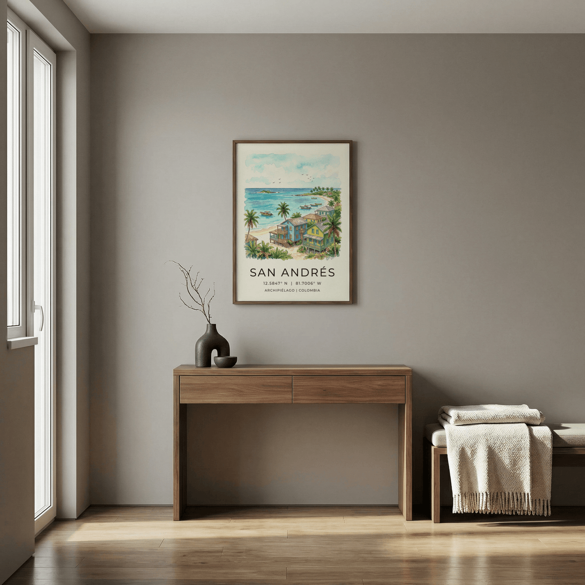 San Andres art print of colourful beach houses and palm trees hung above a wooden desk with a vase