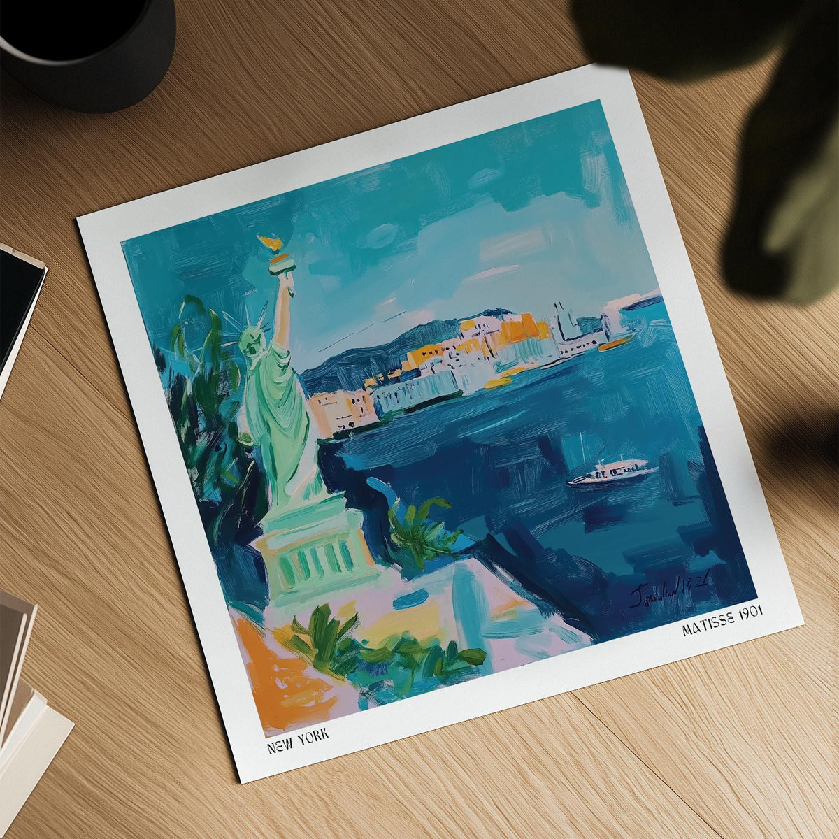 Holiday Posters showing a colourful illustration of the Statue of Liberty in blue and green tones on a wooden table near a mug