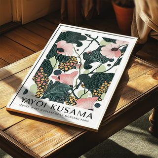 Print leaning on a wooden table with pink flowers and dark green leaves in abstract botanical style