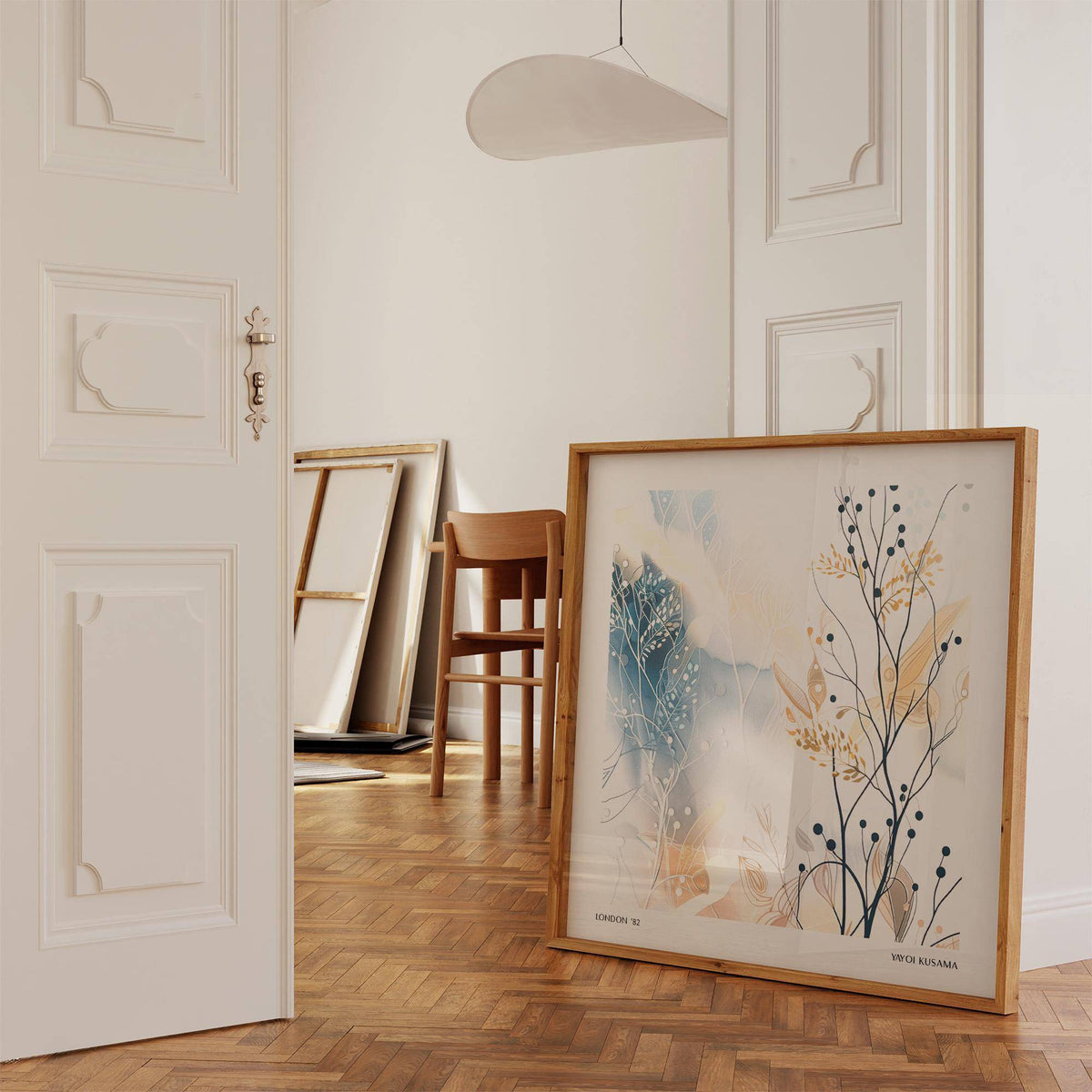 Print leaning on floor with abstract botanical illustration in soft neutral tones near a chair