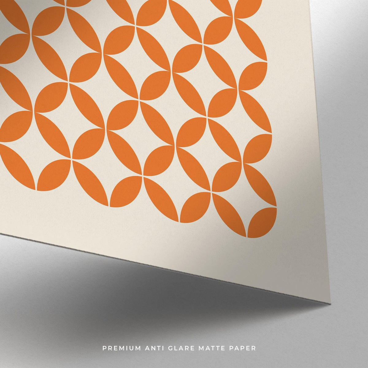 Close-up of orange minimalist print showing part of the orange circle pattern on matte cream paper