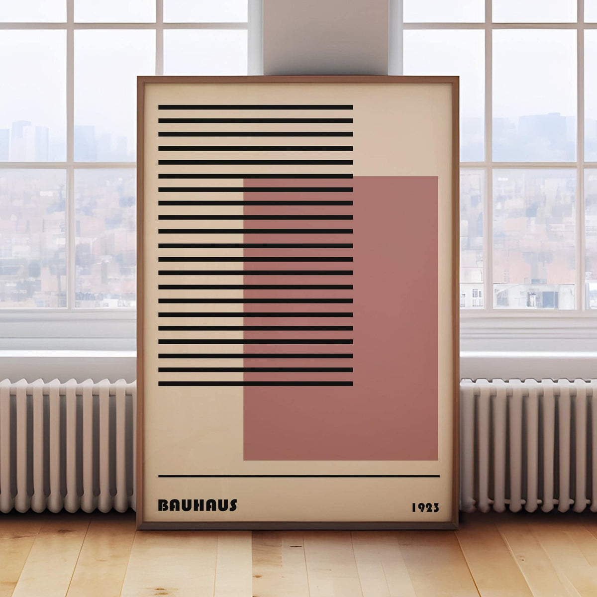 Print leaning on floor of Bauhaus 1923 Art with black horizontal lines and pink square by a white radiator