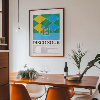 Colorful Posters hanging print of a pisco sour cocktail illustration with geometric shapes in a dining area with a wooden table