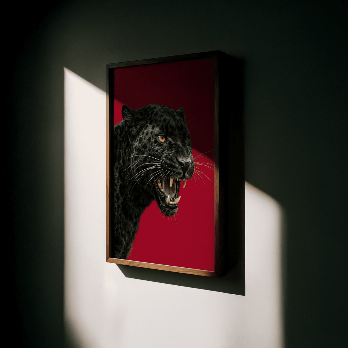 Framed close-up of Wildlife Wall Art with a black panther head on a red background illuminated by sunlight