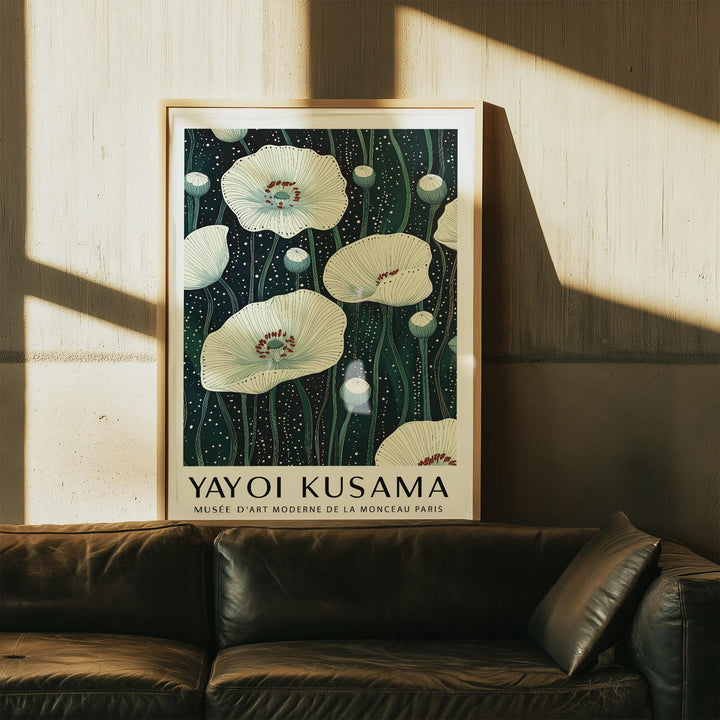Framed Poppy Prints with white poppy flowers and green stems above a dark sofa