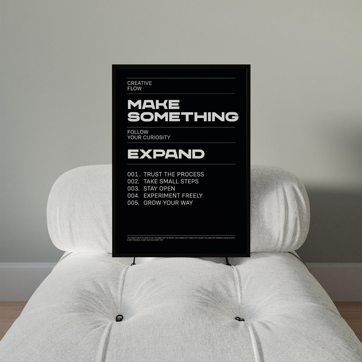 Wall Art Phrases motivational text poster with minimalist typography resting on a white cushioned chair