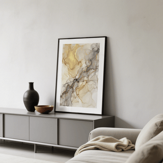 Framed print of Fluid Art Gold Poster with abstract gold and grey veins leaning on a cabinet beside a black vase
