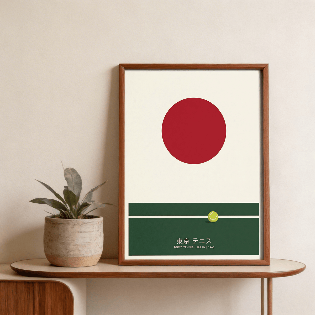 Framed Japanese Tennis Art Print with red circle and green court detail beside a rustic plant pot