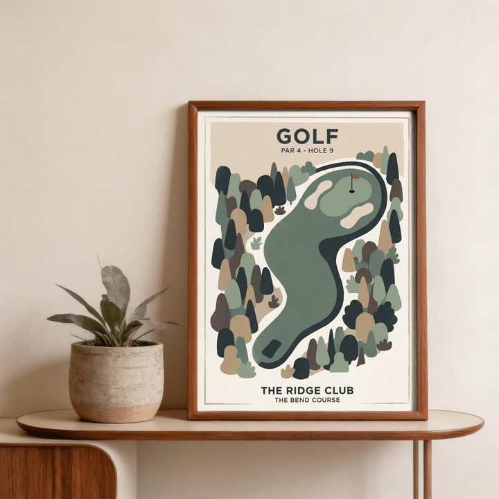 Framed Golf Landscape Print with minimalist golf course hole and muted green tones on a shelf with a plant pot