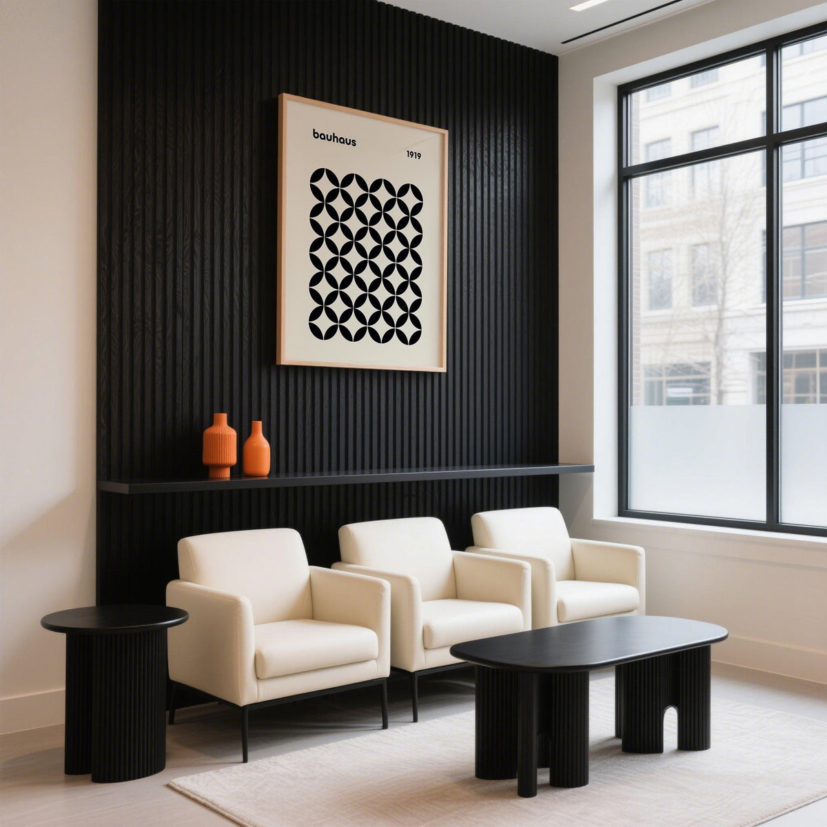 Mid Century wall print with black geometric grid on a black panel wall above white armchairs