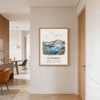 Sydney Watercolor Art Print on a wall featuring the Opera House and Harbour Bridge in soft blues and greens with a dining room nearby