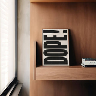 Big Text Poster showing black dope typography text on cream leaning on a wooden shelf with books