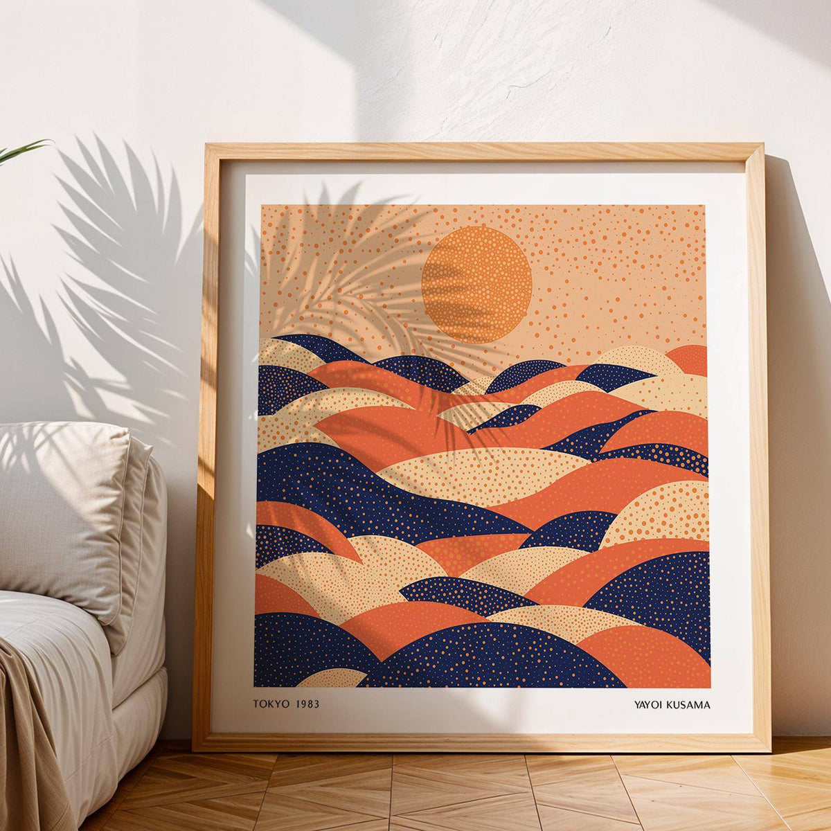 Abstract wall art colourful with orange, navy, and cream dotted hills beside a white couch