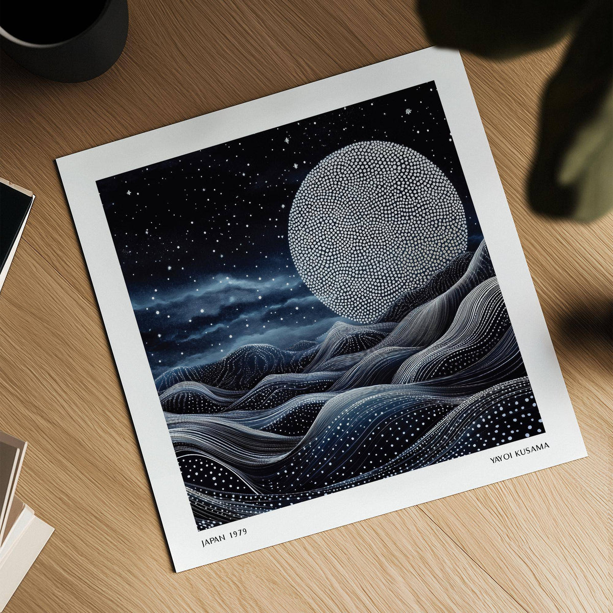 Close-up of surreal moonlit scene print with dotted pattern and abstract waves on wooden table