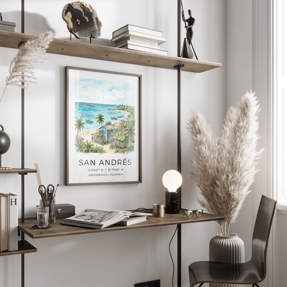 San Andres art print of colourful beach houses and palm trees in a watercolour style on a wall above a desk with a lamp