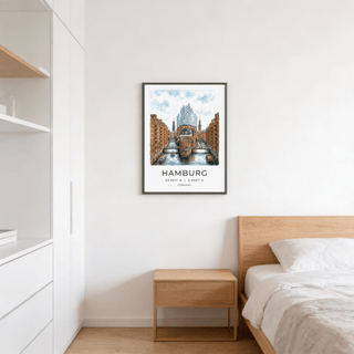 Framed Hamburg Cityscape Art Print with canal and red brick buildings above a wooden bedside table in a bedroom