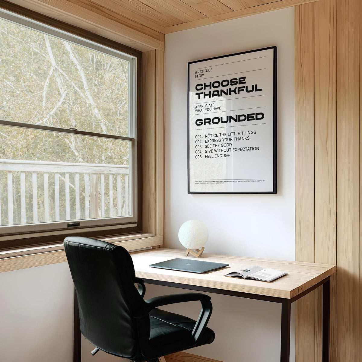 Gratitude wall art typographic black text on white in a light wooden study with a black chair and desk lamp
